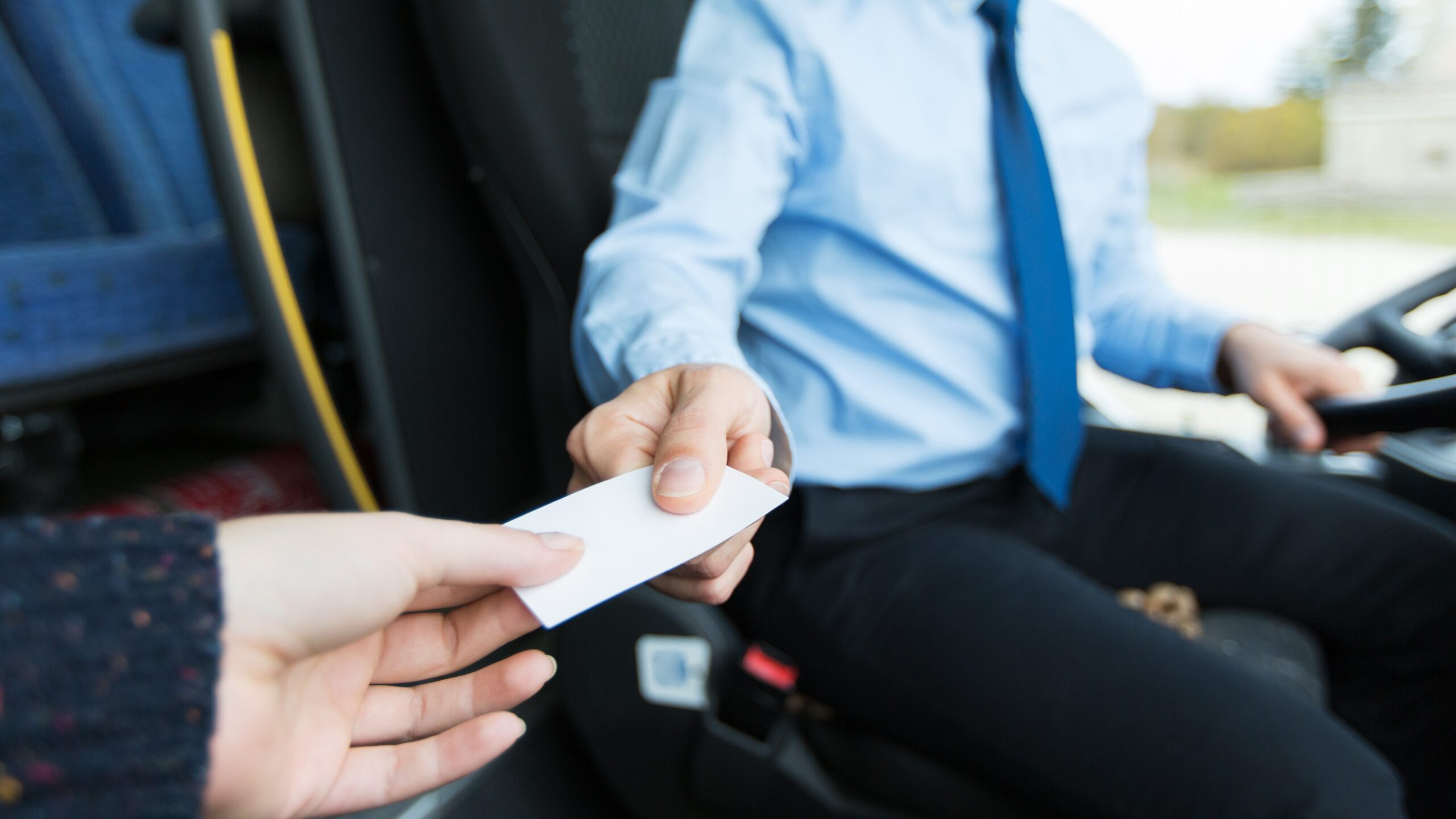 Nahaufnahme eines Busfahrers, der einem Fahrgast ein Ticket verkauft